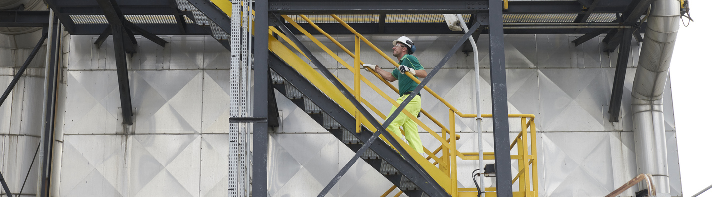 Operator climbs stairs at a plant